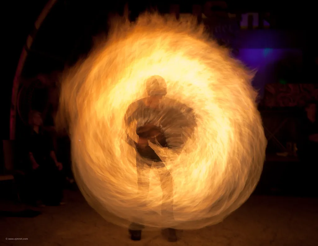 Artista girando un círculo de fuego en la función nocturna (foto de muestra)
